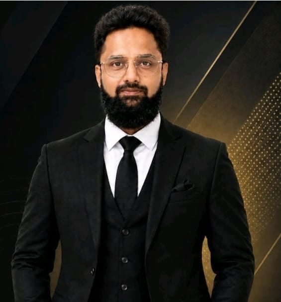 Azhar, Chief Marketing Officer of Faces of Pakistan — bearded man in a black suit, white shirt and black tie against a dark background with gold accents